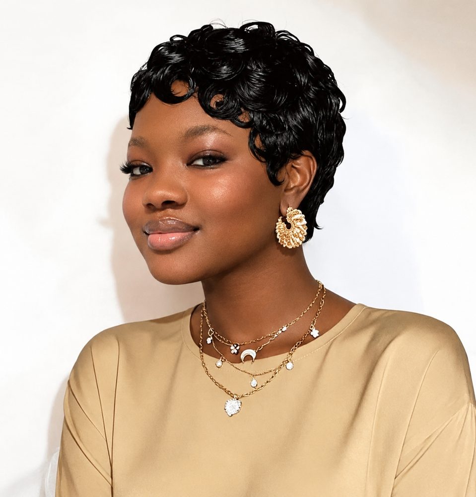 Woman wearing a short black curly pixie cut wig with gold jewellery
